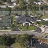 A view of the clubhouse surrounded by tennis courts and swimming pool on the right at Bardmoor Golf & Tennis Club